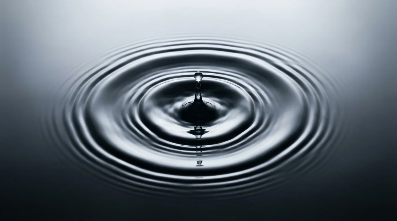 Macro photograph of concentric ripples expanding on a dark water surface, representing geofencing.
